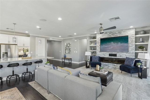 living room with built in features, dark hardwood / wood-style floors, ceiling fan, and ornamental molding