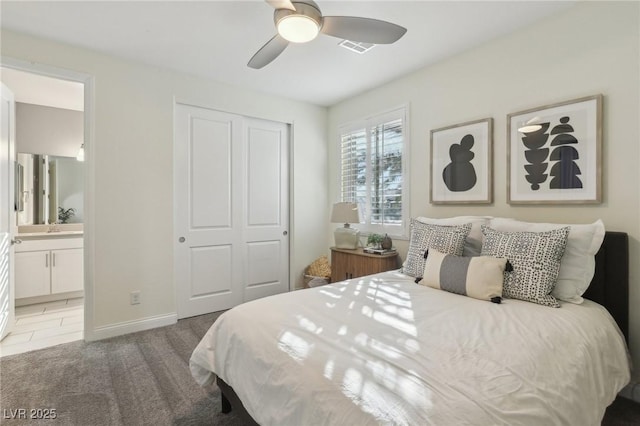 carpeted bedroom with ceiling fan, a closet, and ensuite bath