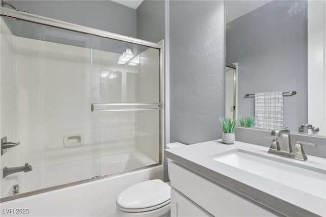 full bathroom with bath / shower combo with glass door, toilet, and vanity