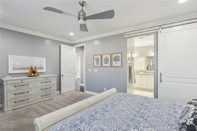 bedroom with connected bathroom, ornamental molding, ceiling fan, light colored carpet, and a barn door