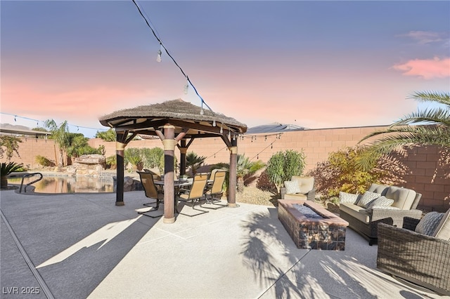 patio terrace at dusk with a gazebo and an outdoor living space with a fire pit