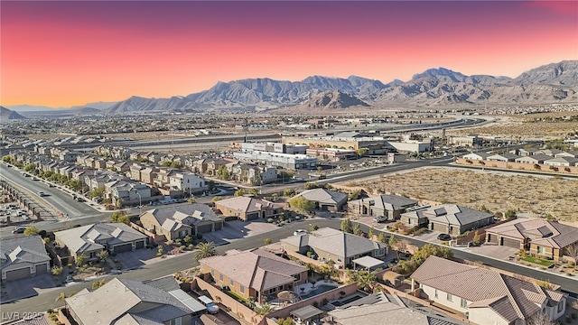 aerial view at dusk featuring a mountain view