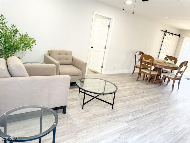 living room featuring light hardwood / wood-style floors and a barn door