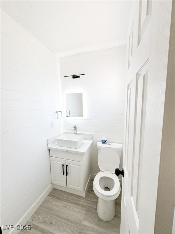 bathroom with vanity, hardwood / wood-style flooring, and toilet