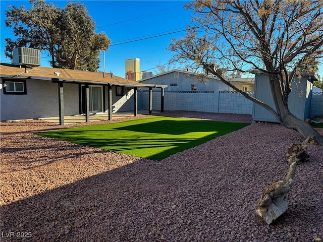 view of yard with central air condition unit and a patio area