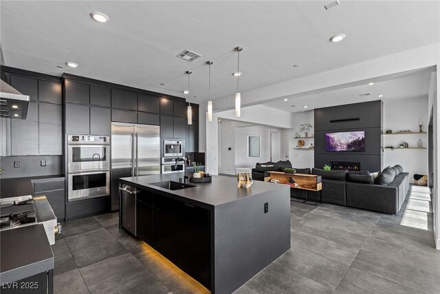 kitchen featuring sink, stainless steel appliances, hanging light fixtures, and a large island