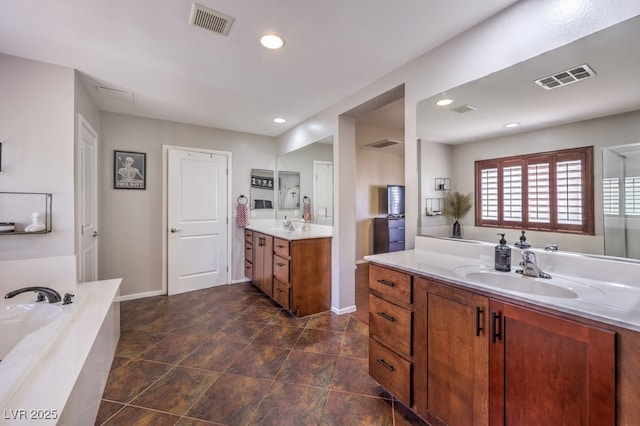 bathroom with vanity and tiled bath