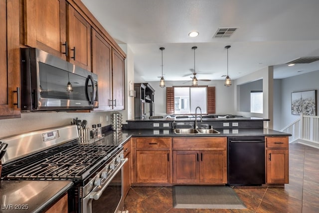 kitchen featuring appliances with stainless steel finishes, dark tile patterned floors, decorative light fixtures, sink, and kitchen peninsula