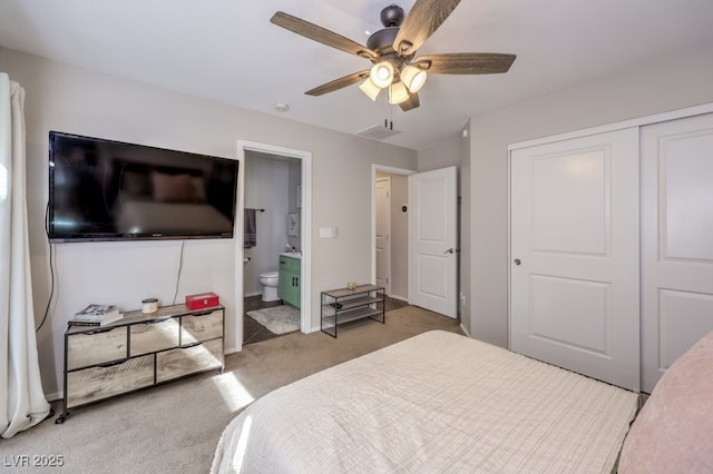 carpeted bedroom with a closet, ceiling fan, and ensuite bathroom