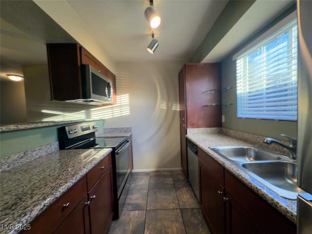 kitchen featuring light stone countertops, sink, and appliances with stainless steel finishes