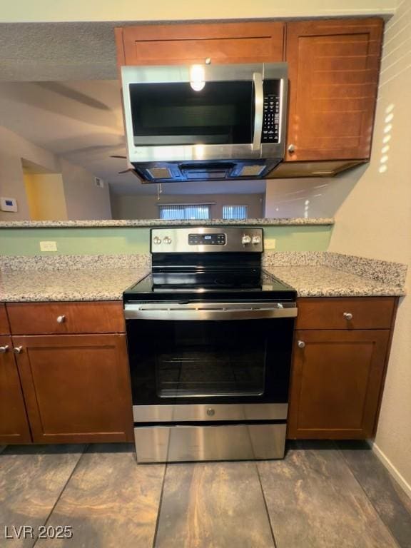 kitchen featuring light stone counters and stainless steel appliances