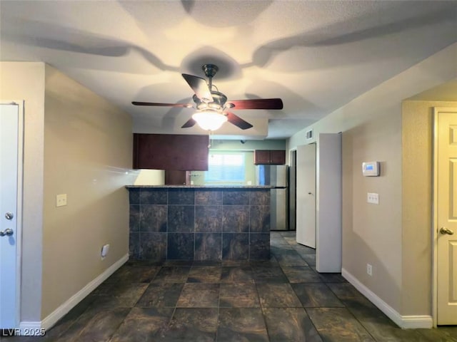 kitchen with kitchen peninsula, stainless steel fridge, and ceiling fan