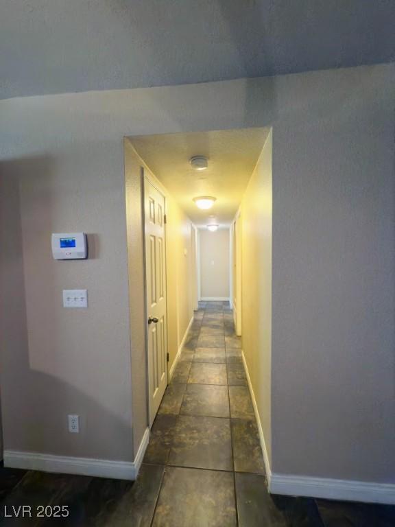 hall with dark tile patterned flooring