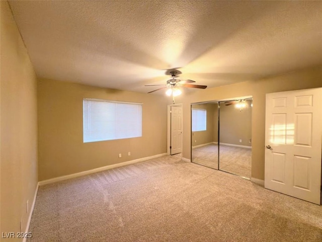 unfurnished bedroom with a textured ceiling, light colored carpet, and ceiling fan