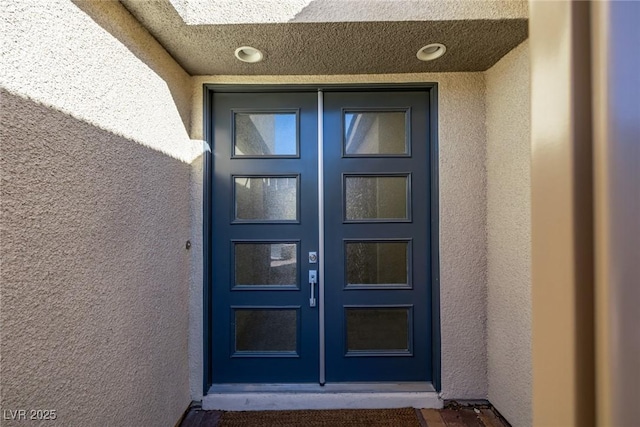 view of exterior entry with stucco siding