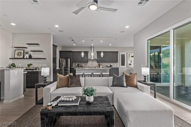 living area featuring light wood-type flooring, visible vents, and recessed lighting