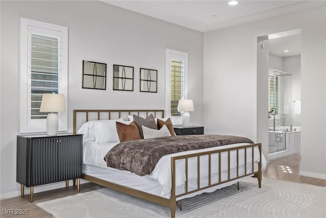 bedroom with ensuite bath, baseboards, wood finished floors, and recessed lighting