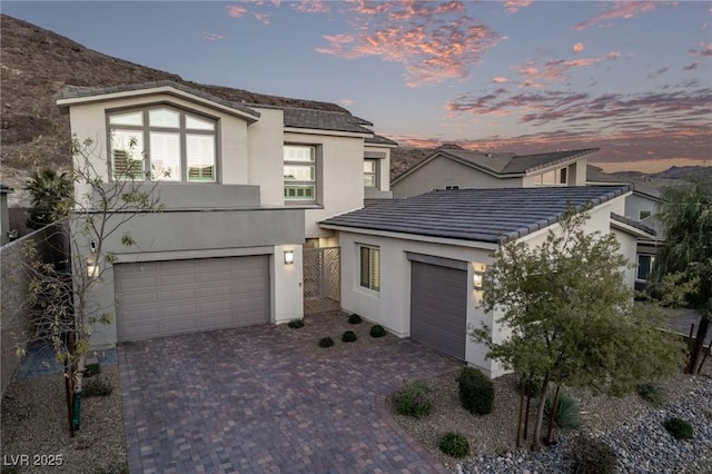 view of front of property with decorative driveway, a tiled roof, and stucco siding