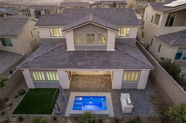 back of property with a tile roof, a fenced backyard, a patio, and stucco siding