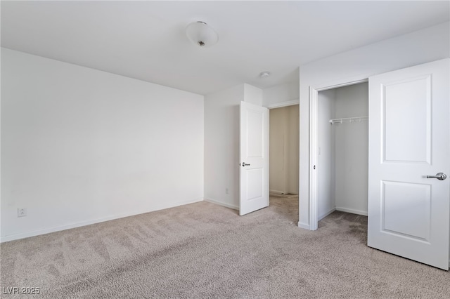 unfurnished bedroom with light colored carpet and a closet