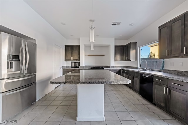 kitchen featuring a breakfast bar area, hanging light fixtures, black appliances, a kitchen island, and dark stone counters