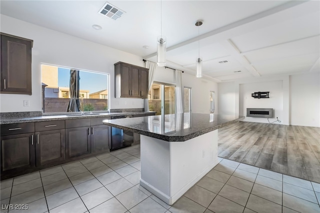 kitchen with a center island, dark brown cabinets, a kitchen breakfast bar, dishwasher, and pendant lighting