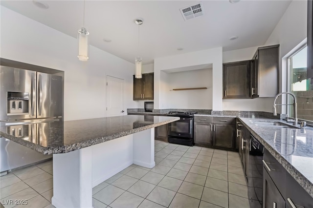 kitchen featuring sink, a kitchen bar, black appliances, light tile patterned flooring, and dark stone counters