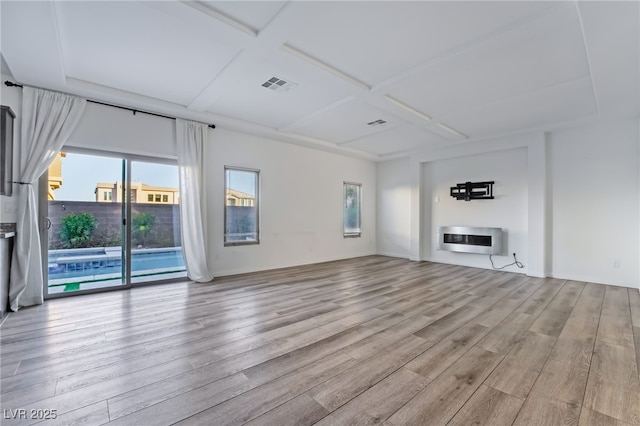 unfurnished living room featuring heating unit, coffered ceiling, and light hardwood / wood-style flooring