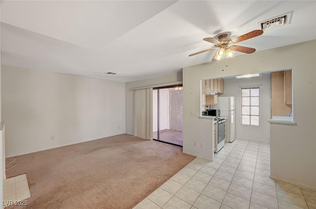 unfurnished living room with light carpet and ceiling fan