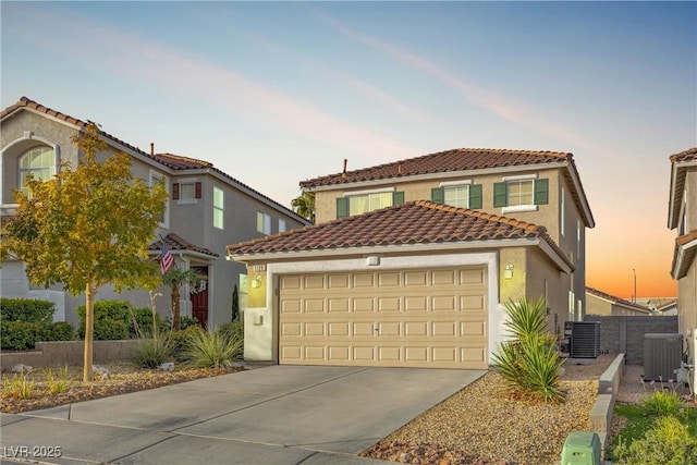 mediterranean / spanish home with a garage and central AC unit