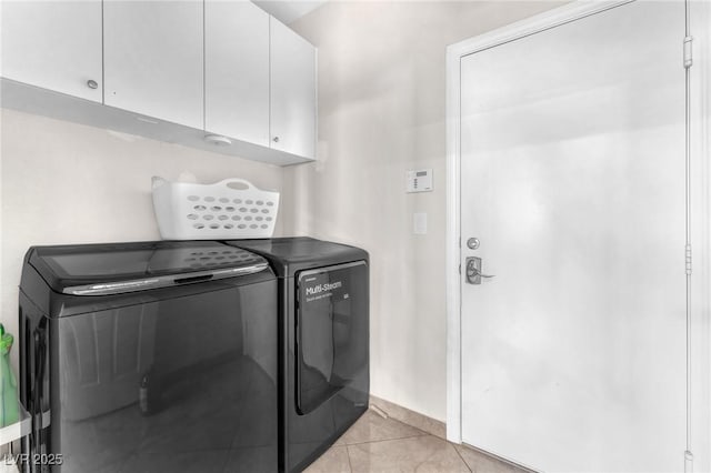 laundry area featuring independent washer and dryer, cabinets, and light tile patterned flooring