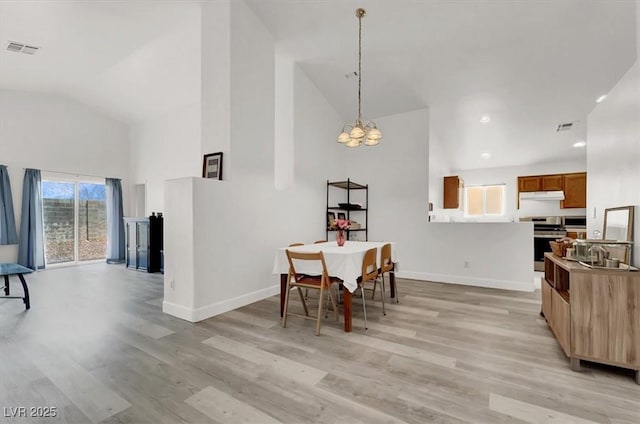 dining area with light wood-type flooring and lofted ceiling