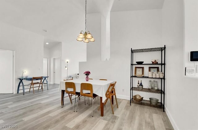 dining space featuring light wood-type flooring and a chandelier