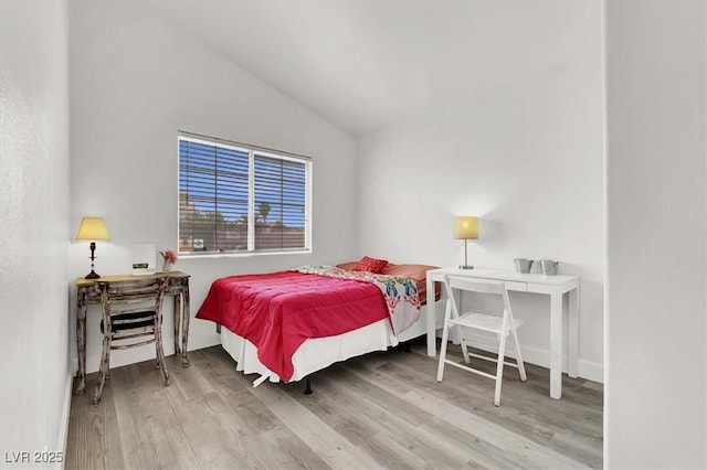 bedroom with hardwood / wood-style flooring and vaulted ceiling