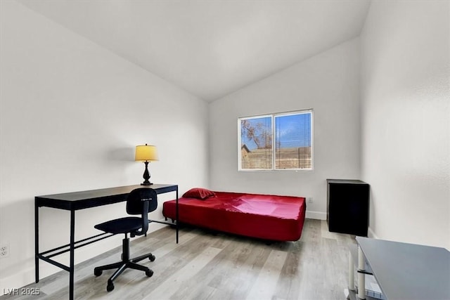 home office with light hardwood / wood-style floors and lofted ceiling