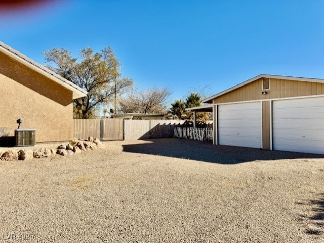 view of yard with a garage, central AC unit, and an outdoor structure