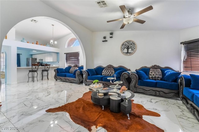 living room with ceiling fan with notable chandelier