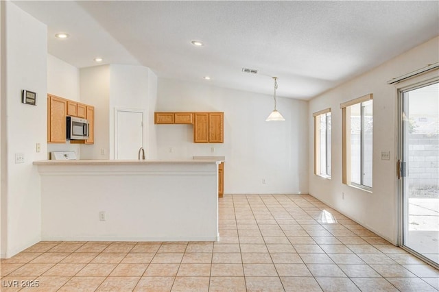 kitchen featuring decorative light fixtures, light tile patterned floors, and lofted ceiling