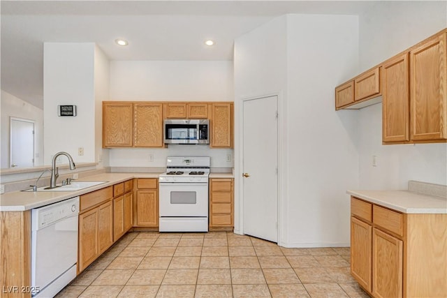 kitchen featuring sink, a towering ceiling, white appliances, and light tile patterned floors