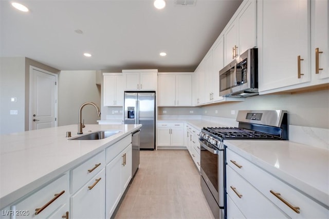 kitchen featuring sink, light stone countertops, white cabinets, and appliances with stainless steel finishes