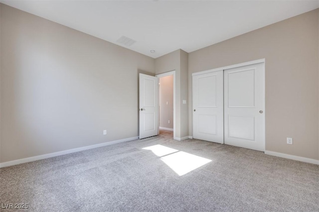 unfurnished bedroom with light colored carpet and a closet