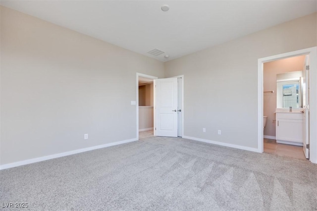 unfurnished bedroom featuring connected bathroom and light colored carpet