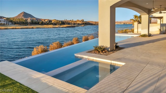 view of swimming pool featuring a water and mountain view and ceiling fan