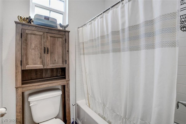 bathroom with toilet and shower / bath combination with curtain