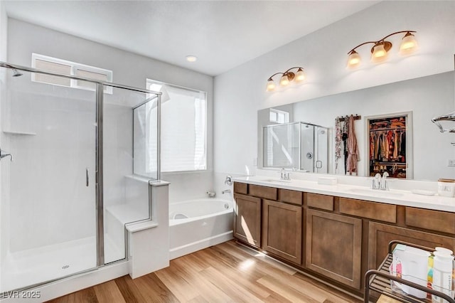 bathroom featuring vanity, hardwood / wood-style floors, and plus walk in shower