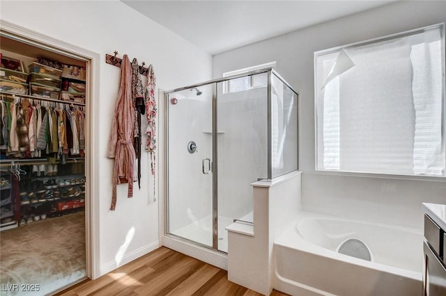 bathroom with hardwood / wood-style floors, plenty of natural light, independent shower and bath, and vanity