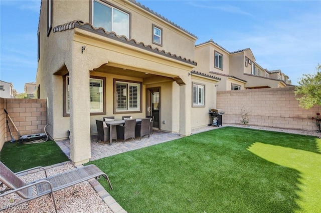 rear view of house featuring a yard and a patio