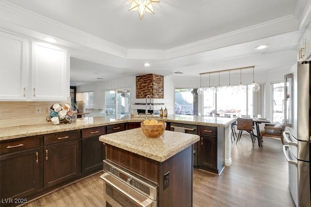 kitchen featuring a center island, pendant lighting, white cabinets, and kitchen peninsula