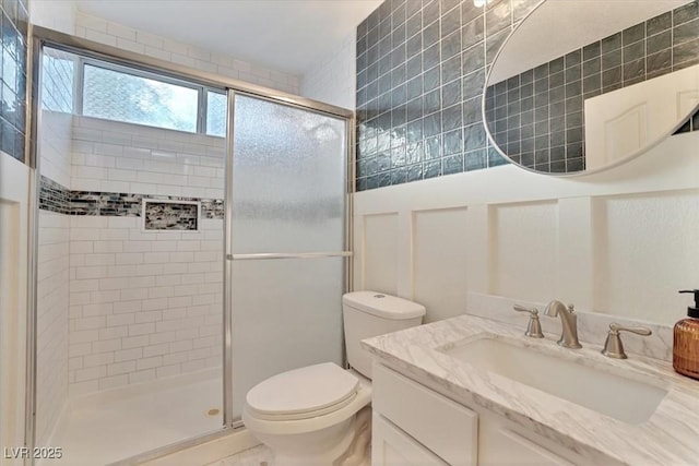 bathroom with walk in shower, vanity, and toilet