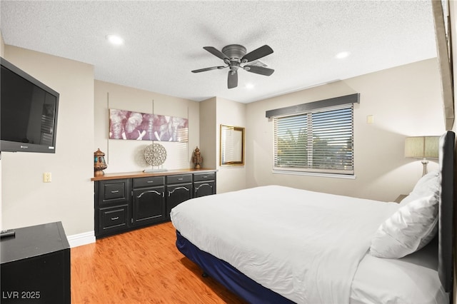 bedroom featuring a textured ceiling, light hardwood / wood-style flooring, and ceiling fan